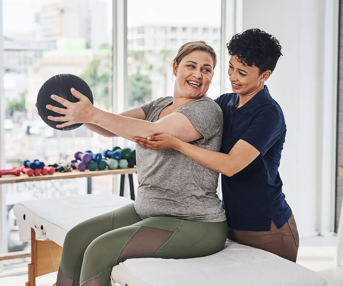 Physical therapist guiding a patient through a hands-on treatment session