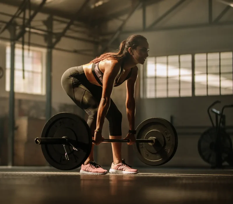 Athlete performing a loaded strength movement under coaching