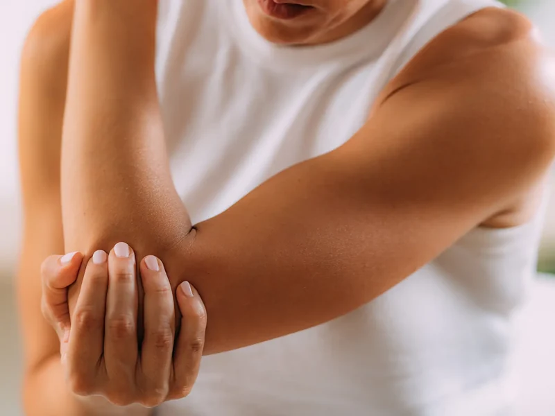 Person holding a painful elbow