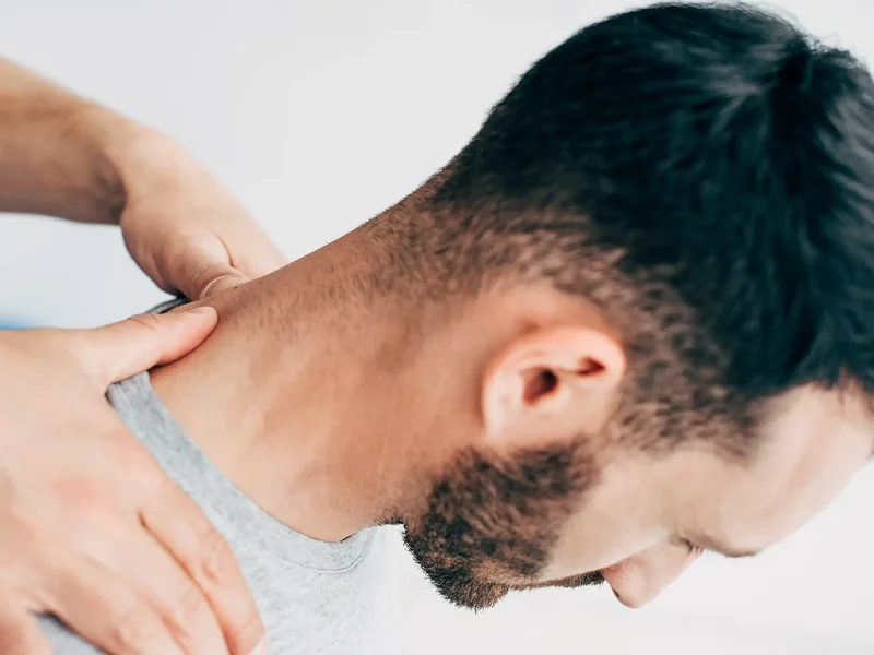 Close-up of hands treating the neck and upper trapezius
