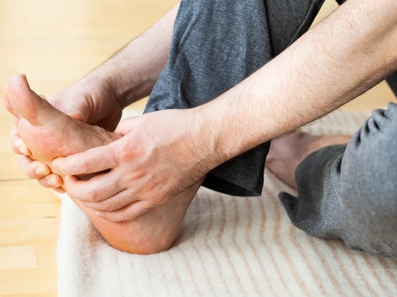 Hands treating the arch and heel of a foot