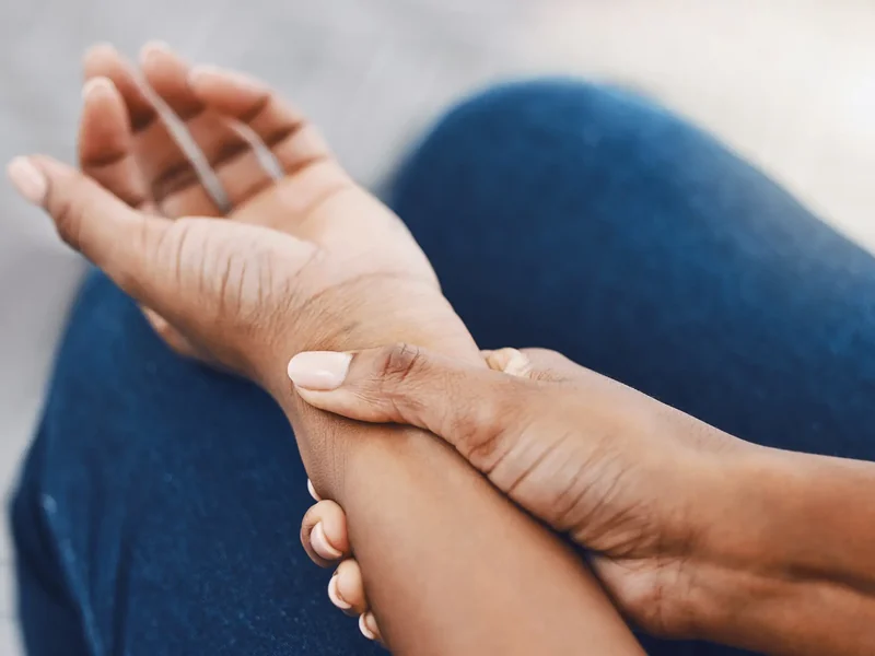 Hands assessing a painful wrist and forearm