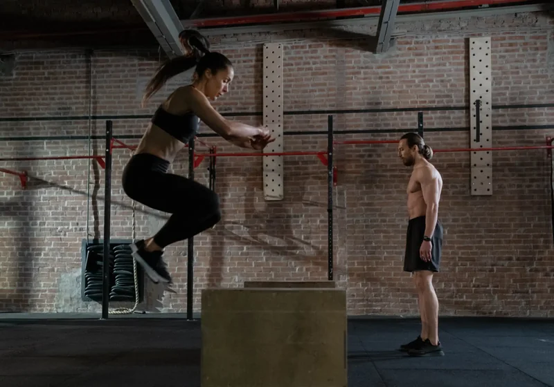 Physical therapist assessing an athlete's shoulder mobility during a CrossFit-style movement