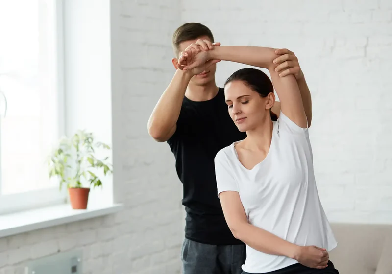 Dr. Peter Dionisopoulos mobilizing a patient's shoulder through its range
