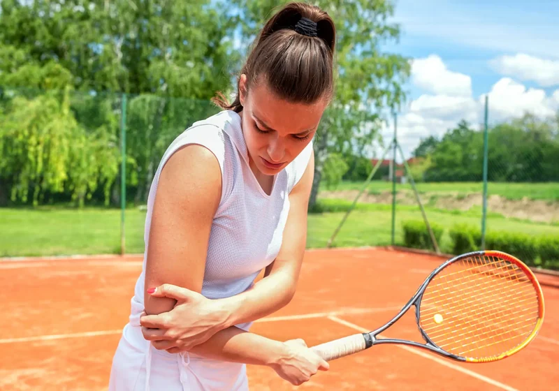Physical therapist assessing a tennis player's shoulder and serving motion