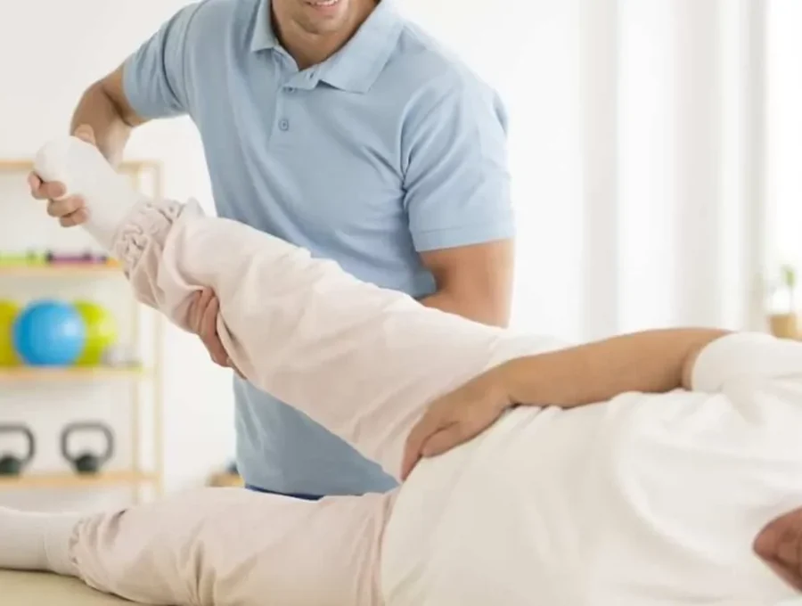 Therapist assessing a patient one-on-one on a treatment table